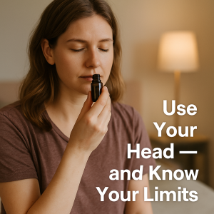 A young woman with light brown hair closes her eyes and breathes in from a dark amber essential oil bottle, practicing aromatherapy. She sits calmly with a neutral background and lamp behind her. Overlaid text reads “Use Your Head — and Know Your Limits.”